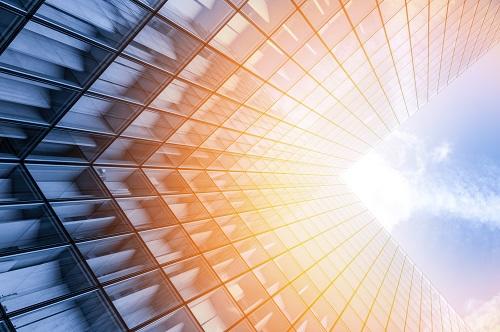 abstract view of a glass building, looking up into the sky. 