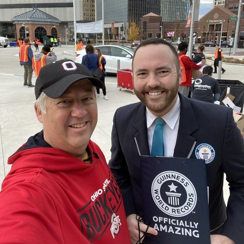 Kyle Sword stands next to Guinness World Record official with award